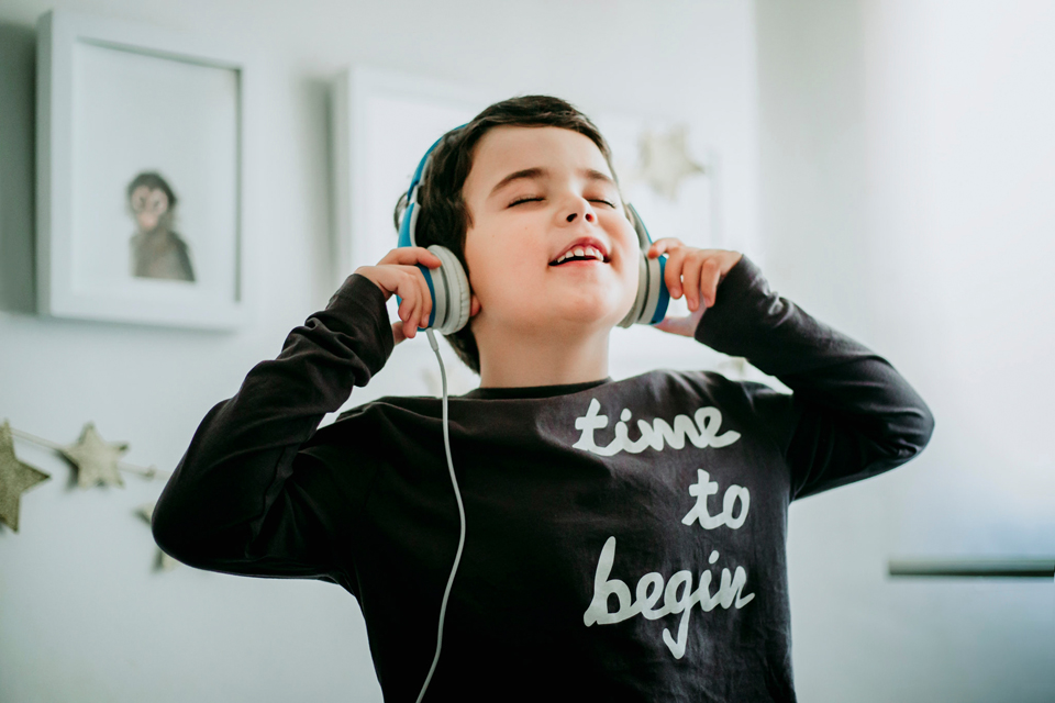 child smiling while listening to a podcast